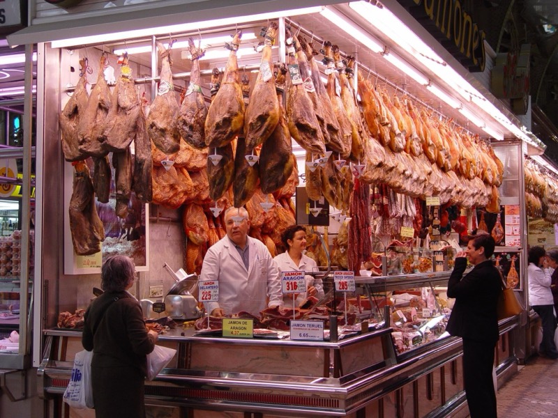 Açougueiros atrás do balcão de um açougue em Valência, na Espanha